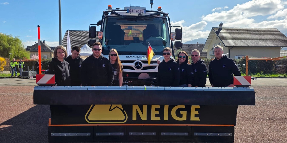 Eine Personengruppe vor einem Unimog.