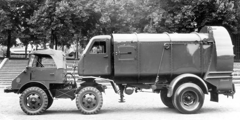 Unimog von Mercedes-Benz, ausgestattet mit einem Müllwagenaufbau, steht seitlich auf einem Platz. Der LKW zeigt robuste Konturen und funktionale Merkmale.