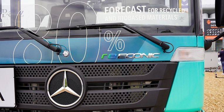 Frontansicht eines Mercedes-Benz Busses mit dem Schriftzug "80% reSONIC" und der Botschaft über recycelte und biobasierte Materialien.